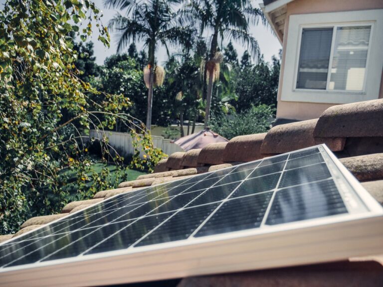 Green neighborhood with solar-paneled homes and bicycles illustrating an eco-friendly lifestyle.